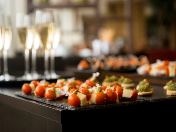 a selection of small bites on trays, flutes of champagne in the background